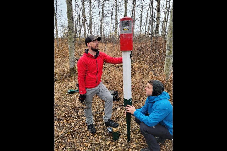 Josh Stokmans and Tim Atchison install some of the tonal targets at the Chuck's Puddle Disc Golf Course, October 16, 2021.