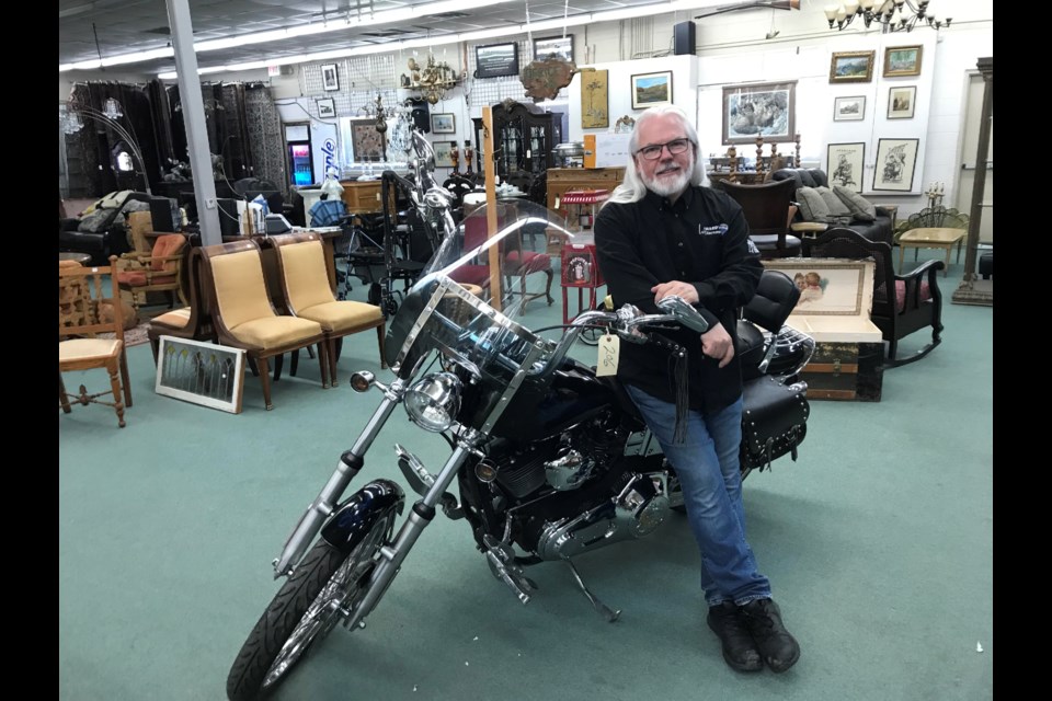 Brad Ward, owner/operator of Ward's Auction, poses with a 2001 Harley Davidson Dynawide glide at the company's Edmonton showroom. The motorbike sold at auction for $8,100 in late February.  Photo; Gary Poignant