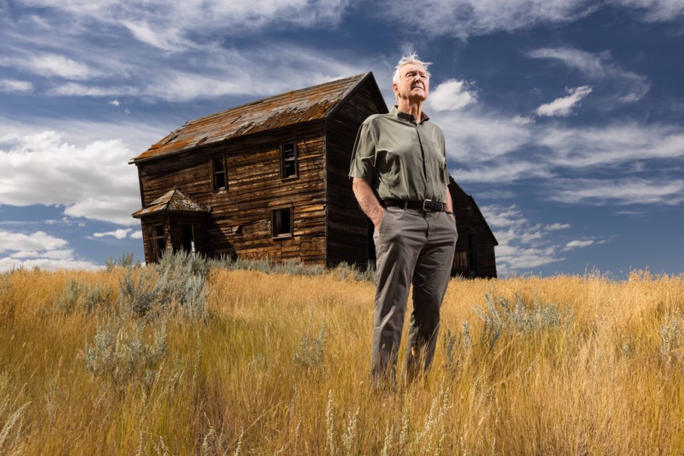 Ron Thorson stands in front of his childhood homestead in southern Alberta, in the wheat grass his father planted in the 40s. Photo by Robert Scott.