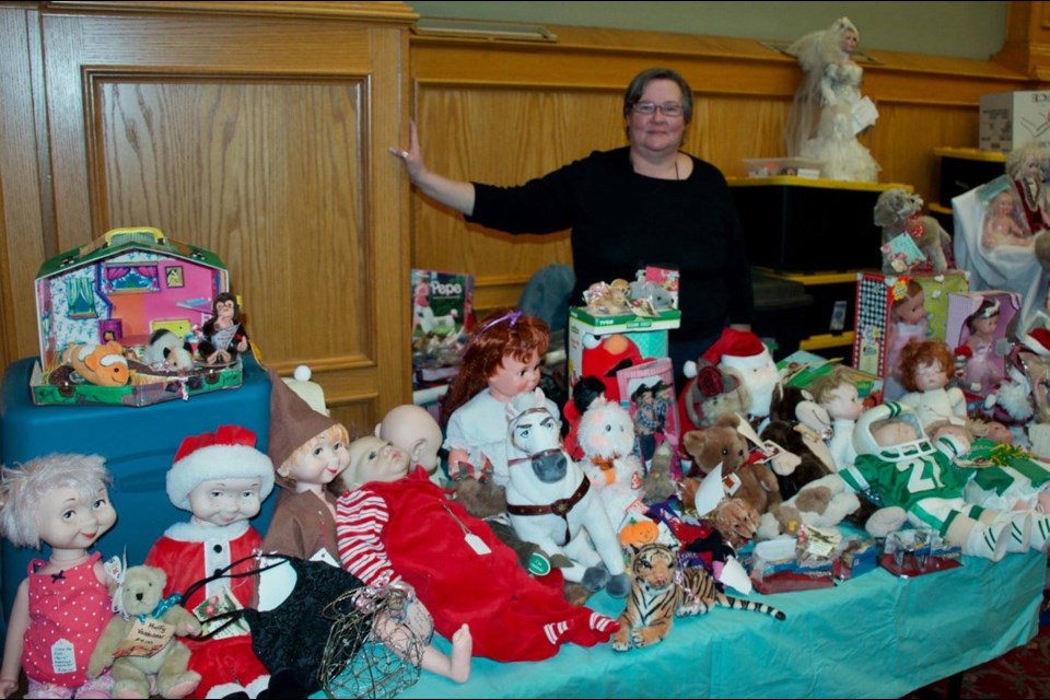 Dawn-Marie Nokleby stands behind one of the many displays at the Doll Club of Edmonton’s big show and sale, held every September at the Italian Cultural Centre. Photo supplied.