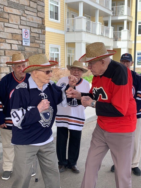 98-year-old Gilbert Paradis (left) and rival Calgary fan John Gilliard get in the spirit for The Battle of Alberta. At the St. Albert Retirement Residence, this kind of recreational fun is just another day in the life. Photo supplied.