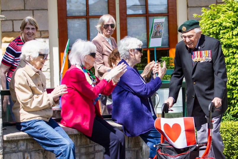 John Hillman gets encouragement from residents as he completes his daily laps around his Carlton House of Oak Bay retirement home. Hillman has pledged to complete 101 laps of the courtyard in a bid to raise $101,000 for Save the Children Canada's pandemic fund. (via Glacier Media)
