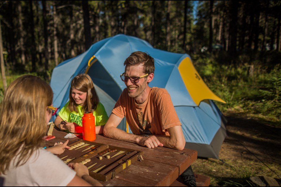Jasper National Park communications spokesman Steve Young enjoys a game of backgammon with his family at Wapiti campground.