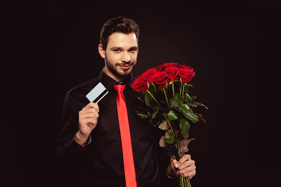 handsome-man-holding-credit-card-and-roses-while-l-2023-11-27-05-19-46-utc