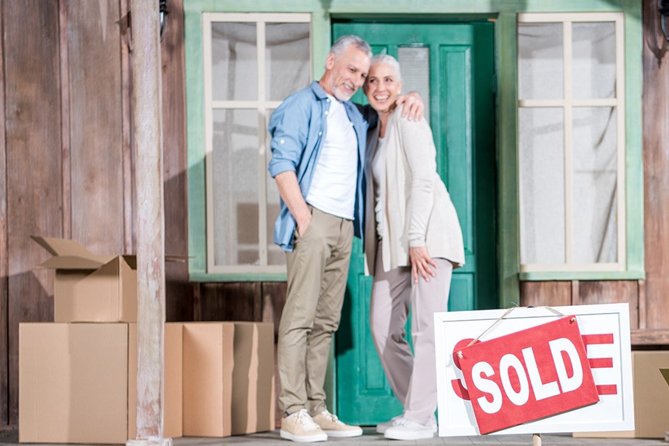 happy-senior-couple-standing-on-porch-of-new-house-NEW