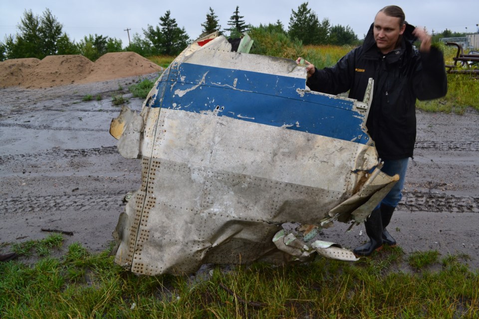 Alberta Aviation Museum Head Curator Lech Lebiedowski holds one of the larger recovered pieces of fuselage that will be displayed at the museum.
