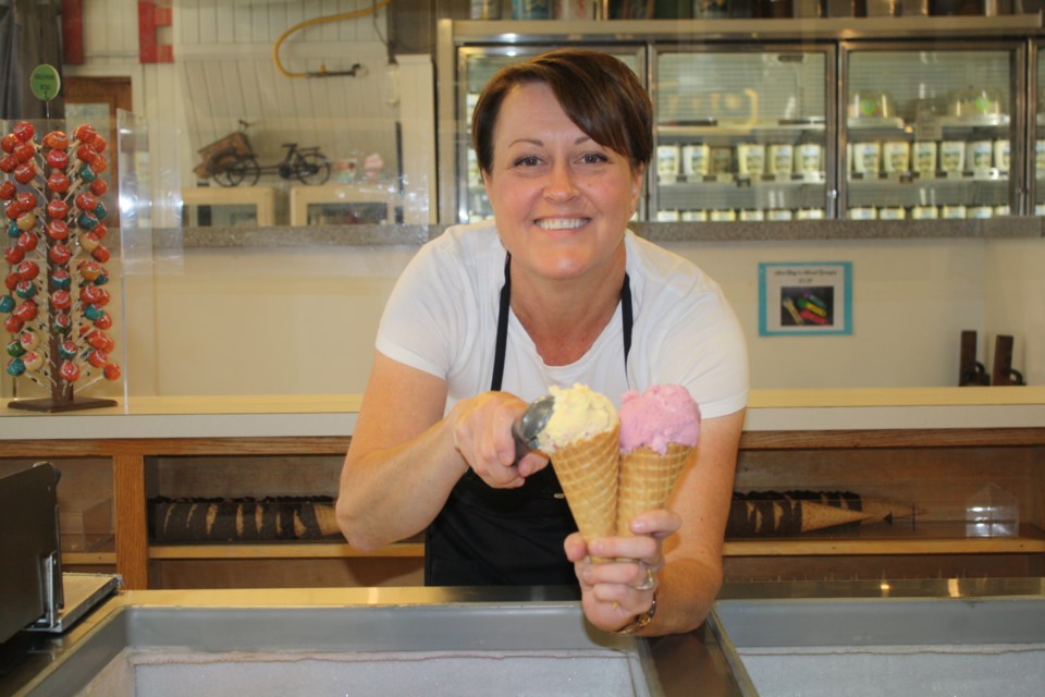 Meghan Tayfel, owner of MacKay's Cochrane Ice Cream, scoops cones in the family owned business of 75 years. Tayfel and her husband Mark are the third generation owners. Photo Sylvia Cole.