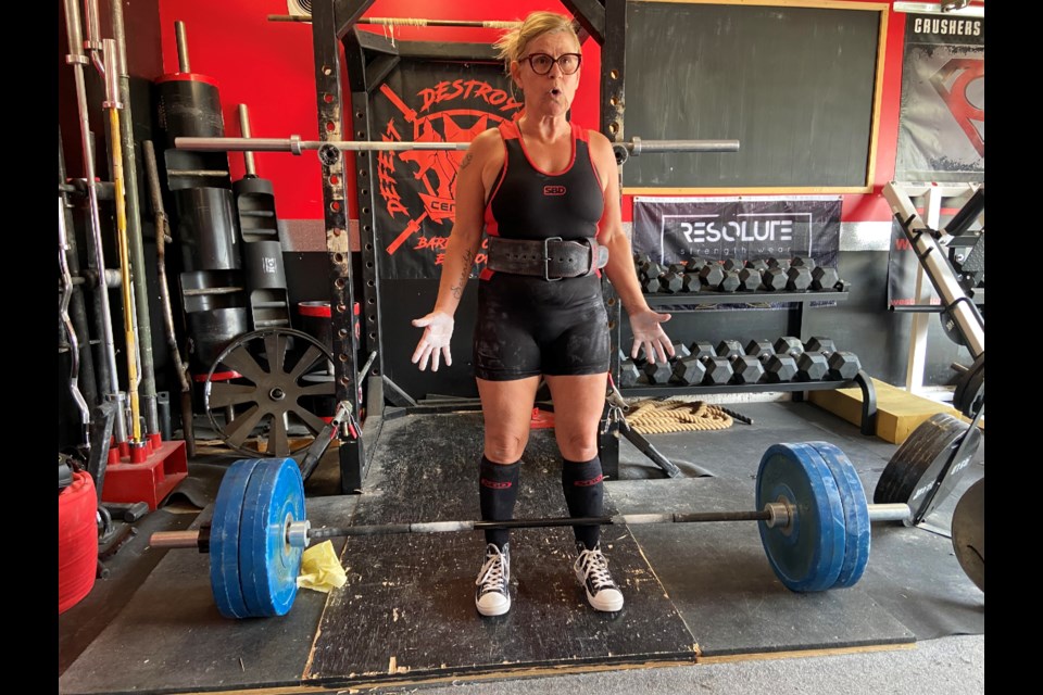 Marion Peterson is all business as she prepares to deadlift 250 pounds in Crushers Gym, a converted double garage in Morinville. Photo; Gary Poignant