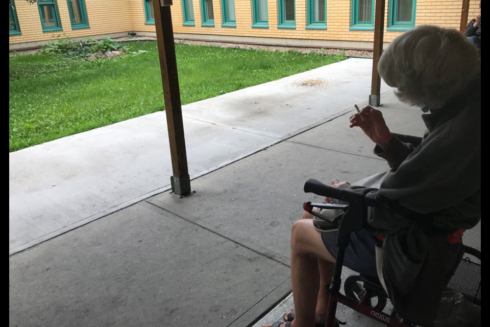 A resident at Villa Marguerite in Edmonton uses the facility's outdoor smoking area. Photo: Gary Poignant 