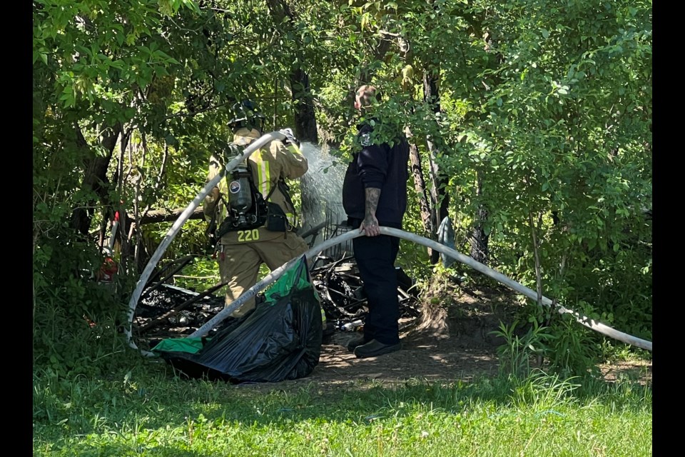 A body was discovered as firefighters extinguished a fire at a wooded area downtown that has been used as a homeless encampment.