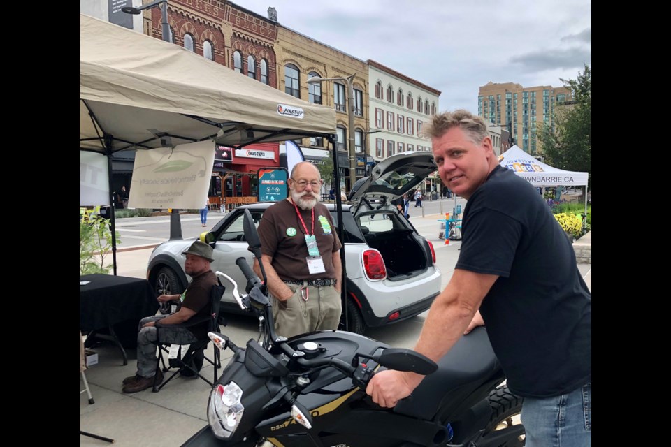 Peter Bursztyn shows off his Mini while Marty Lancaster talks about what he liked about his Zero motorcycle as part of an electric car demonstration, Saturday in downtown Barrie.