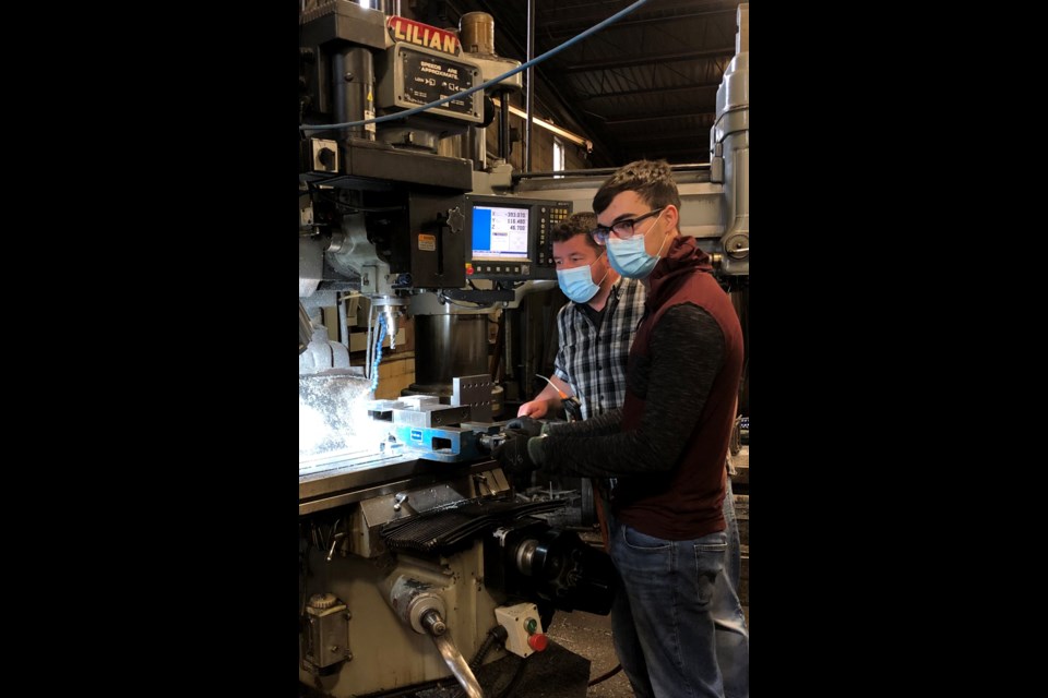 A.B.A. Machine & Welding's general manager Chad Mullins works with firs-year machinist apprentice Connor Barber.