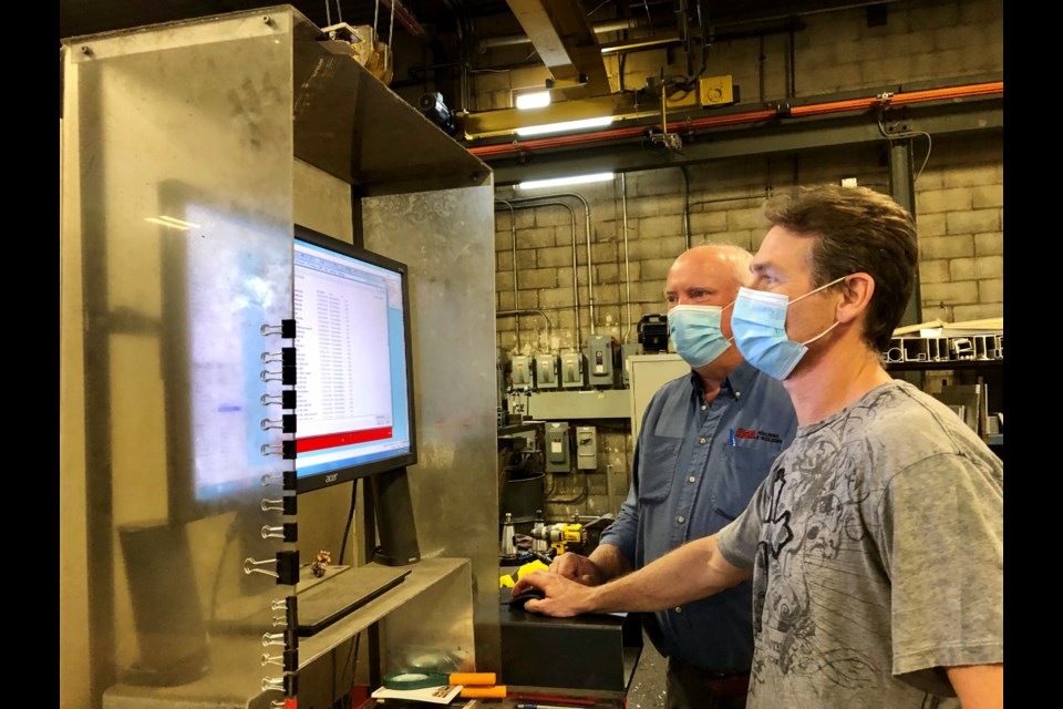 Mike Campbell, left, with Greg Applegate, runs a CNC machine at A.B.A. Machine & Welding.
