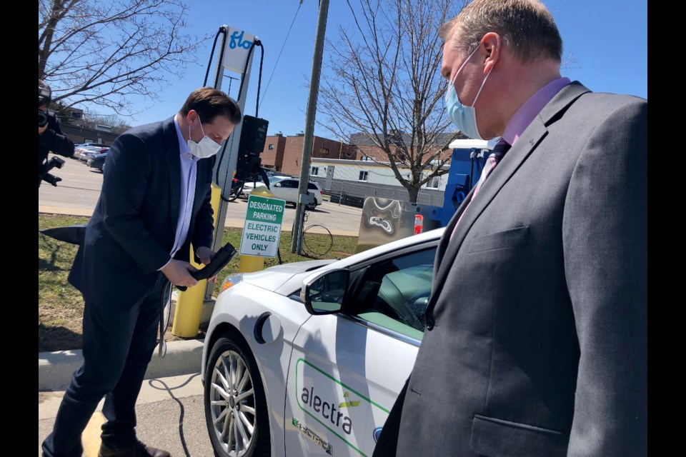 Marco Mendicino, the federal security minister, charges an electric car at Georgian College with vice-president Kevin Weaver on Thursday, April 14.