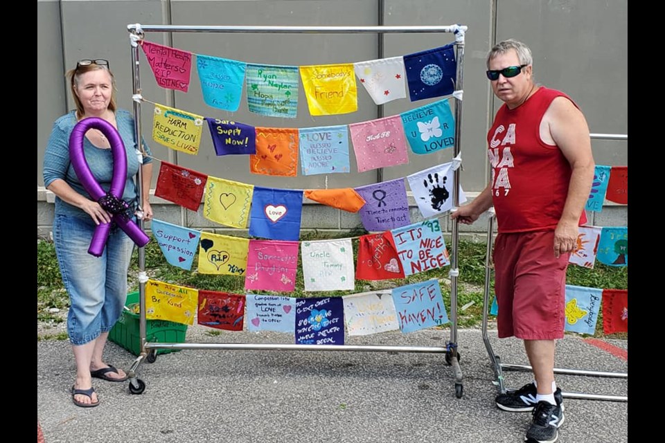Christine and Tom Nayler with the community-made Flags of Hope from the 2021 International Overdose Awareness Day.