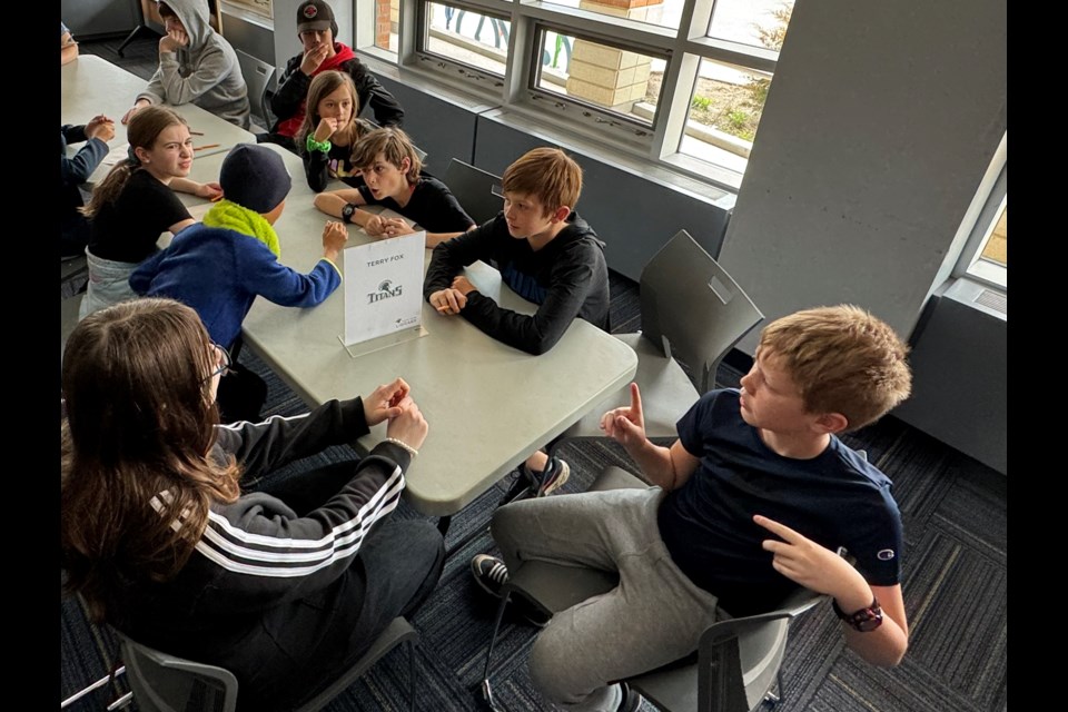 Students from Trillium Woods Elementary School brainstorm together to find the answer to a trivia question during the 2024 Battle of the Books.