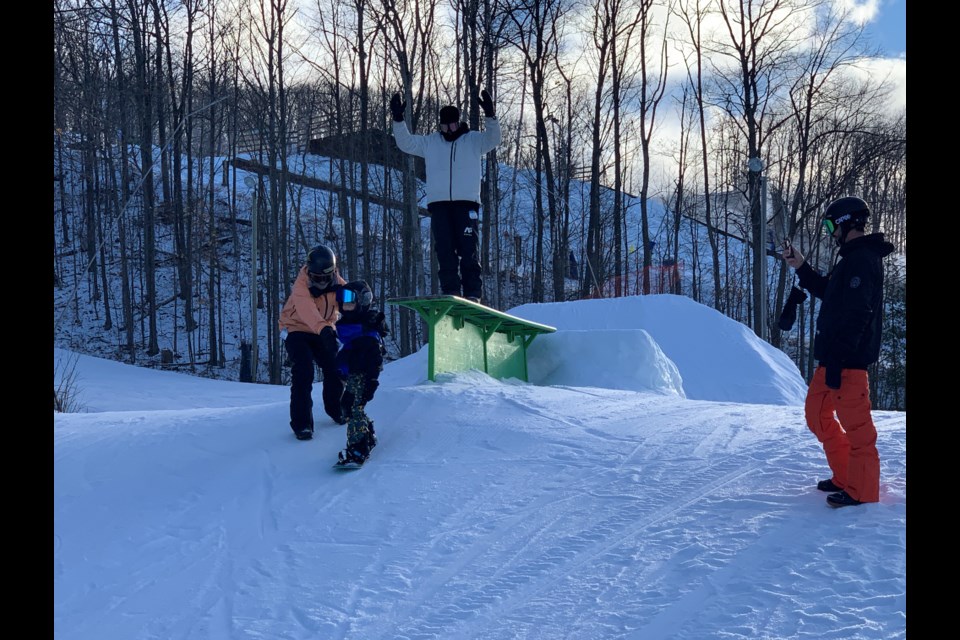 Team Burton riders Kody Williams and Mikey Ciccarelli give a hand to six-year-old Braxton Clayton from Port Sydney during
Saturday's Burton Mystery Series at Snow Valley Ski Resort in Minesing.