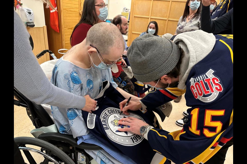 Members of the OHL's Barrie Colts visit with some important fans, who were struck by a vehicle Dec. 1, 2022 on their way to a game at Sadlon Arena.