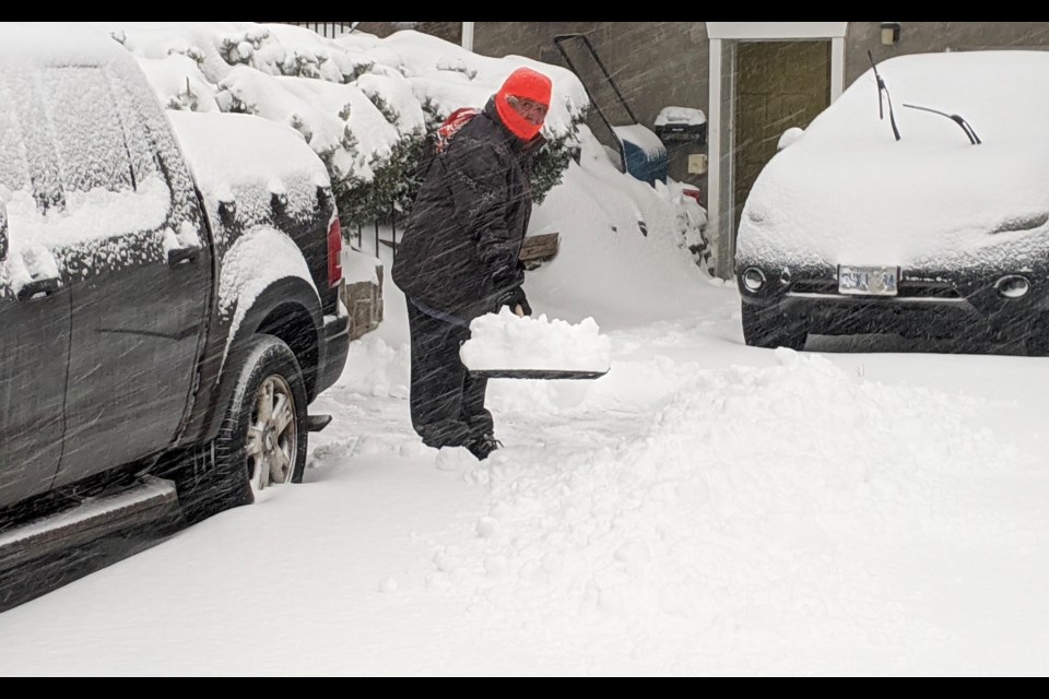 A man shovels his Innisfil Street driveway in Barrie Saturday morning.