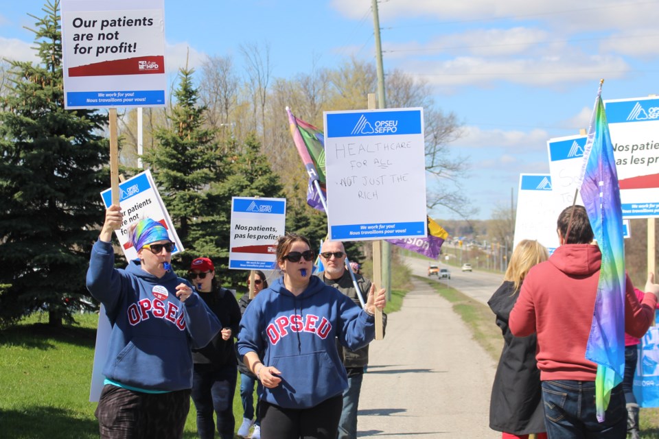 OPSEU Local 346 president Elizabeth Watts and vice-president Stef Wall work to bring attention to Bill 60, which they say is a threat to Ontario's health-care system. A rally was held outside Barrie's Royal Victoria Regional Health Centre on Thursday.