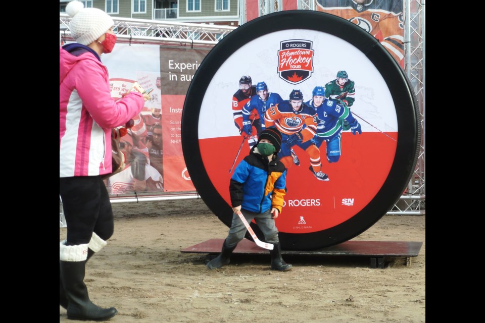 Jaime Rendell photographs son Tyler, 5, at Hometown Hockey on Saturday afternoon.