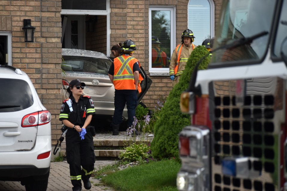 Local emergency personnel respond to the scene of a single vehicle crash after the car drove into the front of a home on Farmstead Cres. in Barrie's south end Friday morning.  