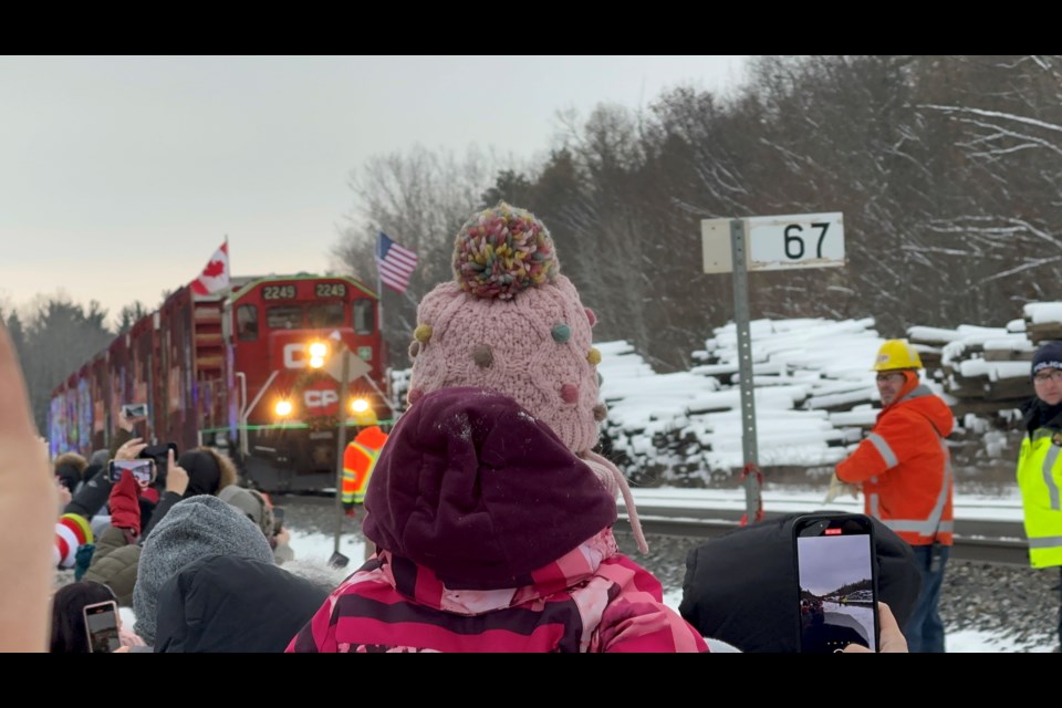 The crowd cheers at the first sight of the CPKC Holiday Train, which made a stop at the Anne Street North rail crossing in Springwater on Wednesday, Nov. 29.