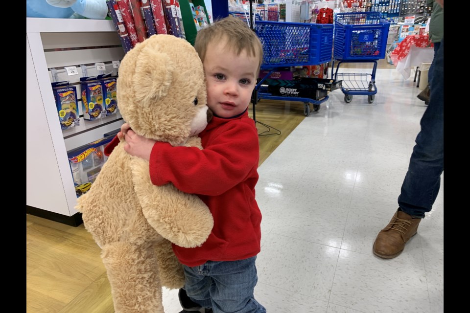 Huxley MacDonald, 2, from Oro-Medonte, gives a teddy bear a big Christmas hug at Toys R Us in Barrie which provided Starlight Children’s Foundation Canada families with a private in-store shopping experience.