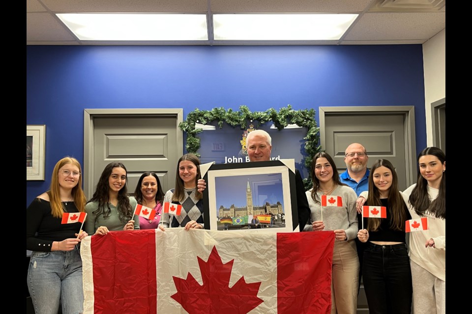 A group of international students who are living in Barrie as part of Canada Home Stay Network presented a framed photo of themselves in front of parliament holding the flags of their home countries to John Brassard, member of parliament for Barrie-Innisfil. 