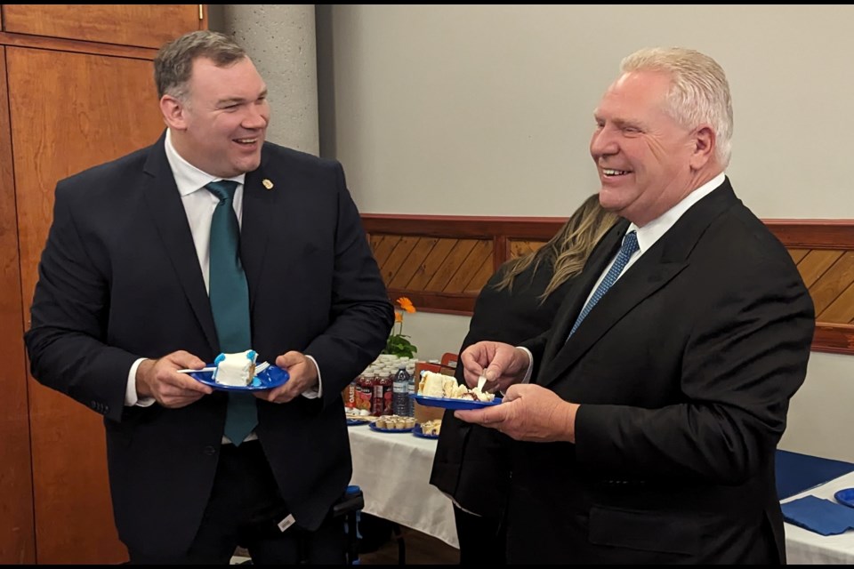 Ontario Premier Doug Ford, right, and Barrie Mayor Alex Nuttall enjoy cake after Friday's $6.34-million funding announcement.