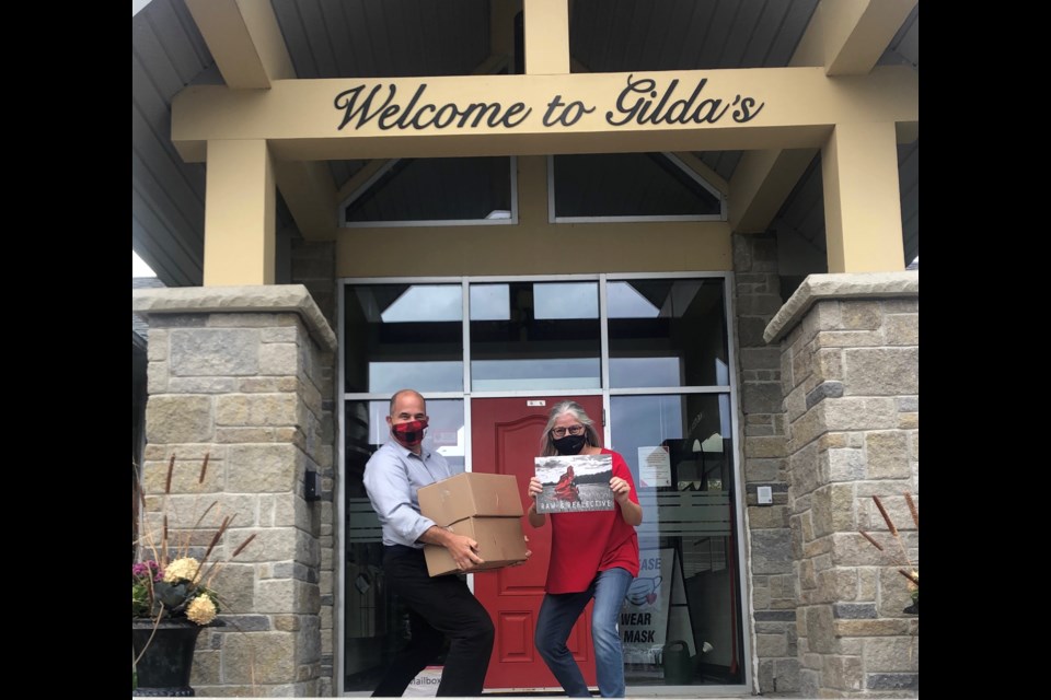 Gilda’s Club Simcoe Muskoka executive director Aaron Lutes, left, and Barrie hairstylist Sharon Smith are shown with boxes of the 2021 calendar for the organization's annual fundraiser. Photo supplied