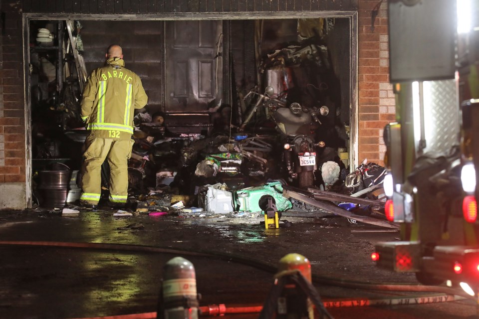A Barrie firefighter inspects the fire damage inside a garage at a residence on Sun King Crescent on Saturday, September 18, 2021. 