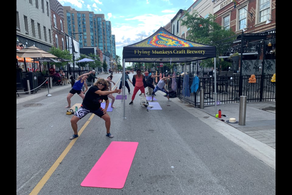 Local pilates instructor Kelly Patterson-McGrath leads a class outside of Flying Monkeys Craft Brewery on July 2 for the inaugural Pets and Pilates event, a fundraiser for the Ontario SPCA Barrie Animal Centre.