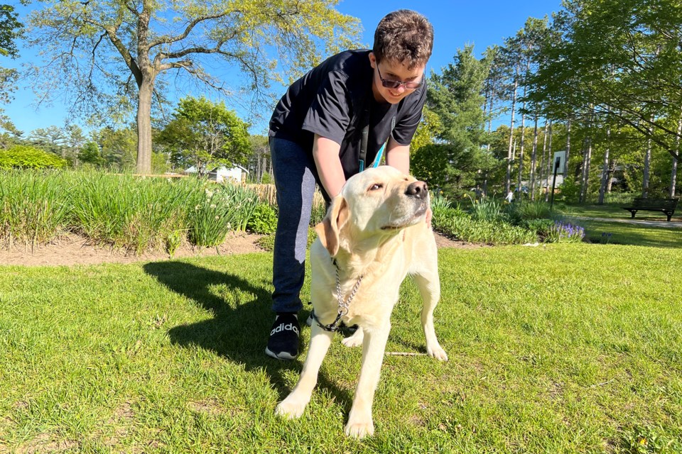 Shawn, Adam Reed's service dog, enjoys a back scratch session from Adam at Sunnidale Park in Barrie.