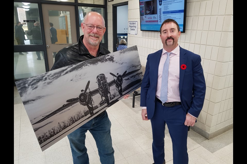 Ian McIntosh (left) is all smiles as Barrie police Const. Mike Mellish returns the photographer's stolen artwork to him at police headquarters, Saturday. Shawn Gibson/BarrieToday