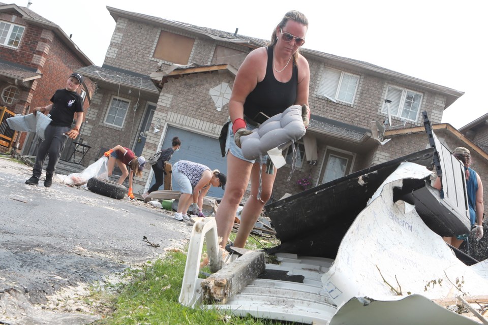 Volunters help homeowners with clean-up efforts Monday morning after a tornado ripped through the south end of Barrie on July 15.
