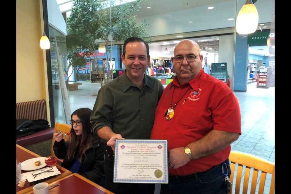 In this photo from Doug Downey's Twitter feed, the Barrie-Springwater-Oro-Medonte MPP (left) receives a certificate naming him 'Gichi Inini' (Great Man) from Chief Bob Lowe of the Algonquin Woodland Aboriginal Peoples’ Tribal Council.