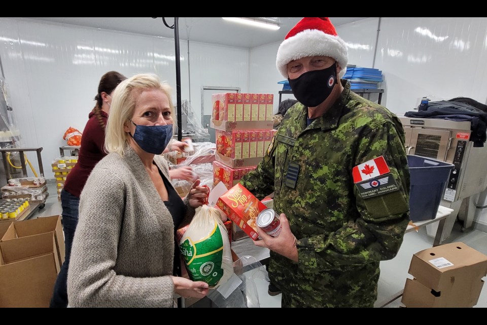 Anneke Lovegrove, left, and Wayne Hay get care 200 packages packed up and ready for a Tuesday delivery to the Barrie and Angus food banks.