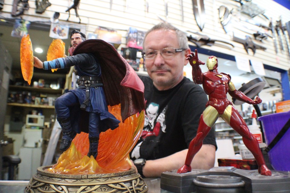Vincent Booth, owner of Sir Games-A-Lot in Barrie's Bayfield Mall, is shown with statues of Doctor Strange (left) and Iron Man, characters that were created by Stan Lee, who died on Monday. Raymond Bowe/BarrieToday