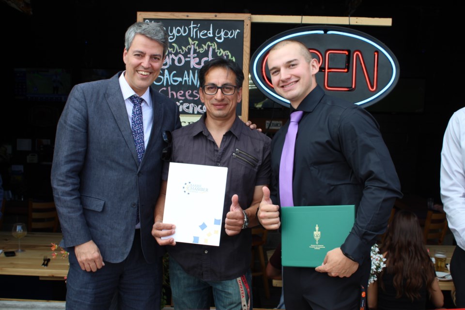 Barrie Chamber of Commerce executive director Richard Brooks (left) presents Ranch 2.0 owner Ed Rios  and his son and business partner Abraham Miller-Rios with a certificate mark the ribbon-cutting on July 12, 2019. Raymond Bowe/BarrieToday