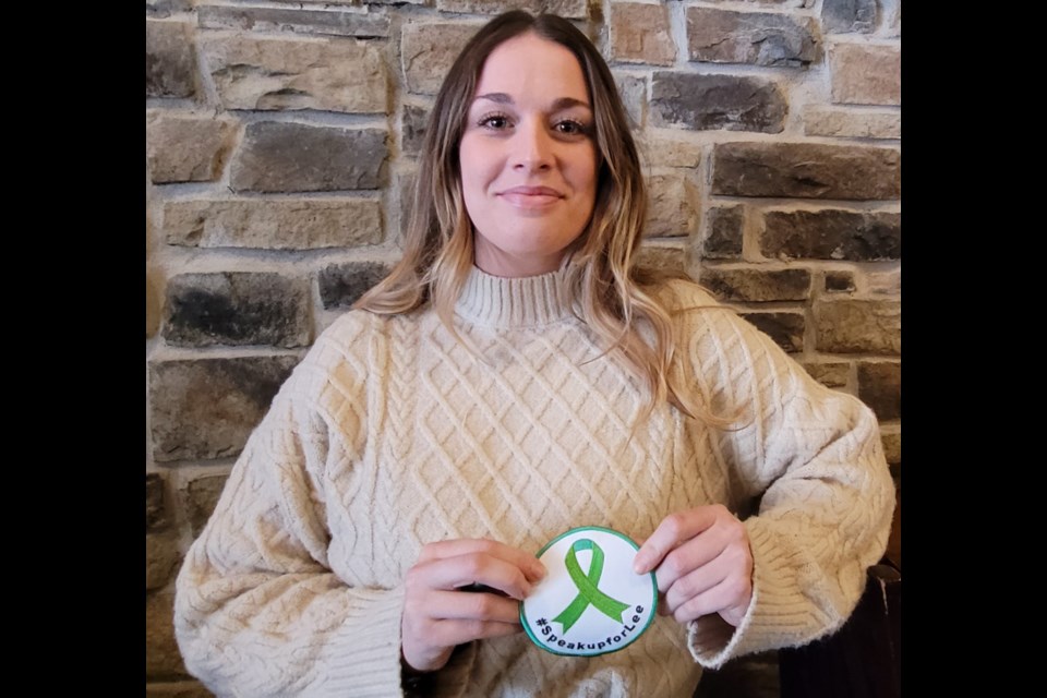 Caroline Duffy shows off the #SpeakUpForLee patch available at Donaleigh's in support of mental health awareness.