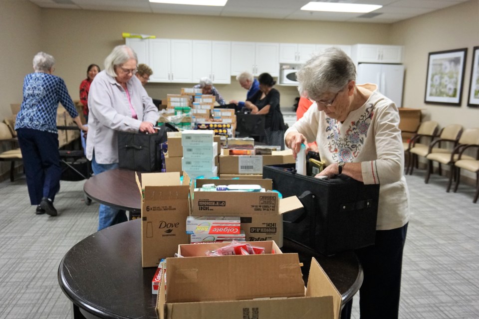 Doris Caravan fills a Christmas basket with items during Amica Little Lake's basket stuffing event. The baskets will be given to less fortunate seniors across Barrie. Jessica Owen/BarrieToday