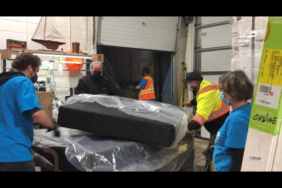 Volunteers unload mattresses donated by Hydro One.