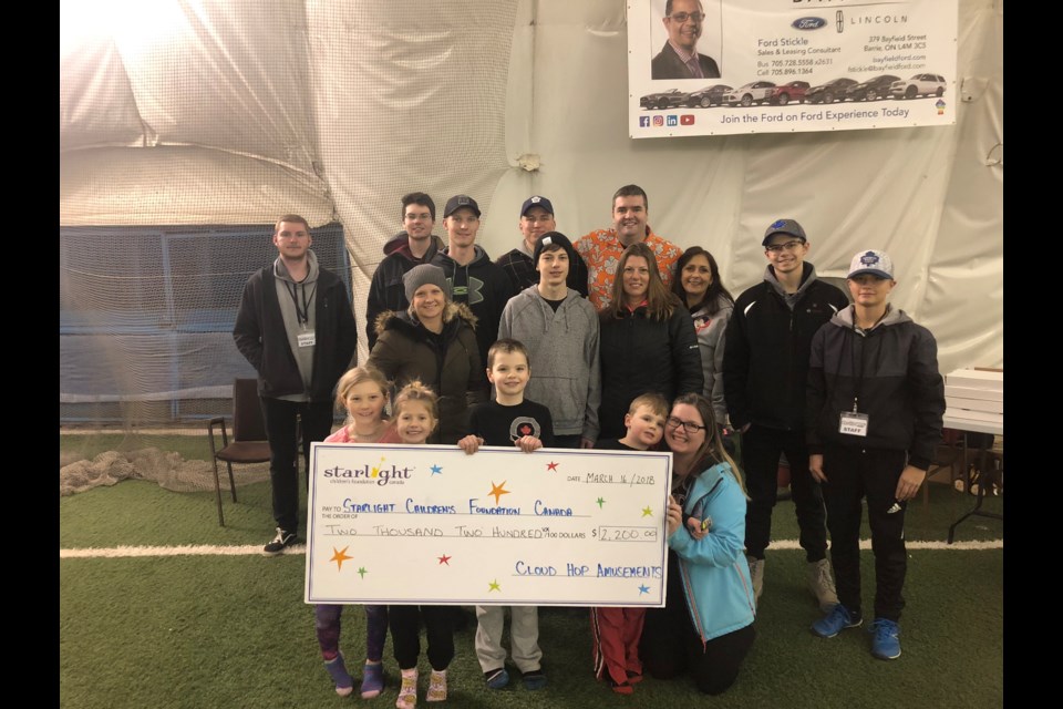 Nathan Miller (black shirt, middle holding cheque) helped create the Barrie Bouncefest for the Starlight Foundation. Photo submitted