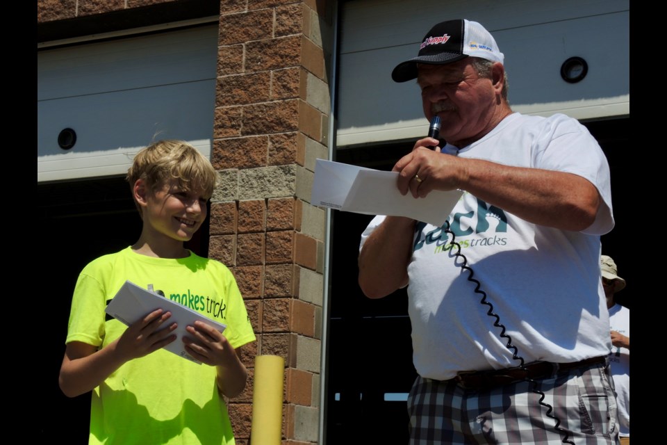 Zach's grandfather Doug Roberts hands over several cheques during a community BBQ Roberts hosted to raise funds for Zach Makes Tracks. Roberts owns Fix Auto Barrie and Roberts Complete Auto Care where the BBQ was held.
Sue Sgambati/BarrieToday          