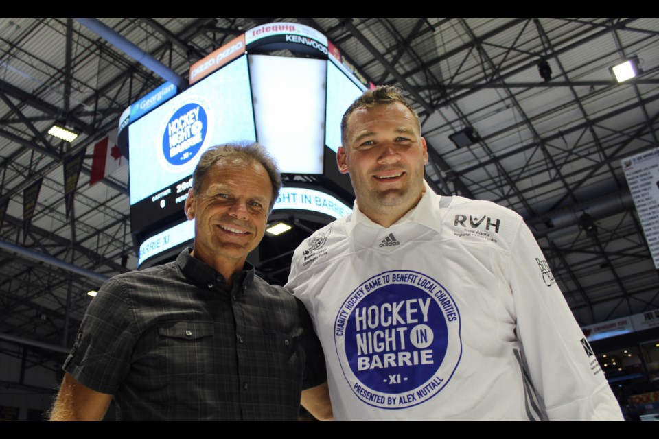 Local MP Alex Nuttall, right, poses with Hockey Hall of Famer Mike Gartner near centre ice at the Barrie Molson Centre. Raymond Bowe/BarrieToday