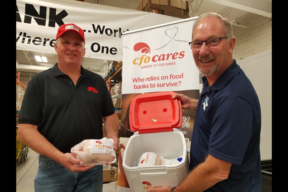 Brian Fieldhouse (left) and Barrie Food Bank executive director Peter Sundborg show off some of the chicken which is a healthy option for those who use the food bank services. Shawn GIbson/BarrieToday
