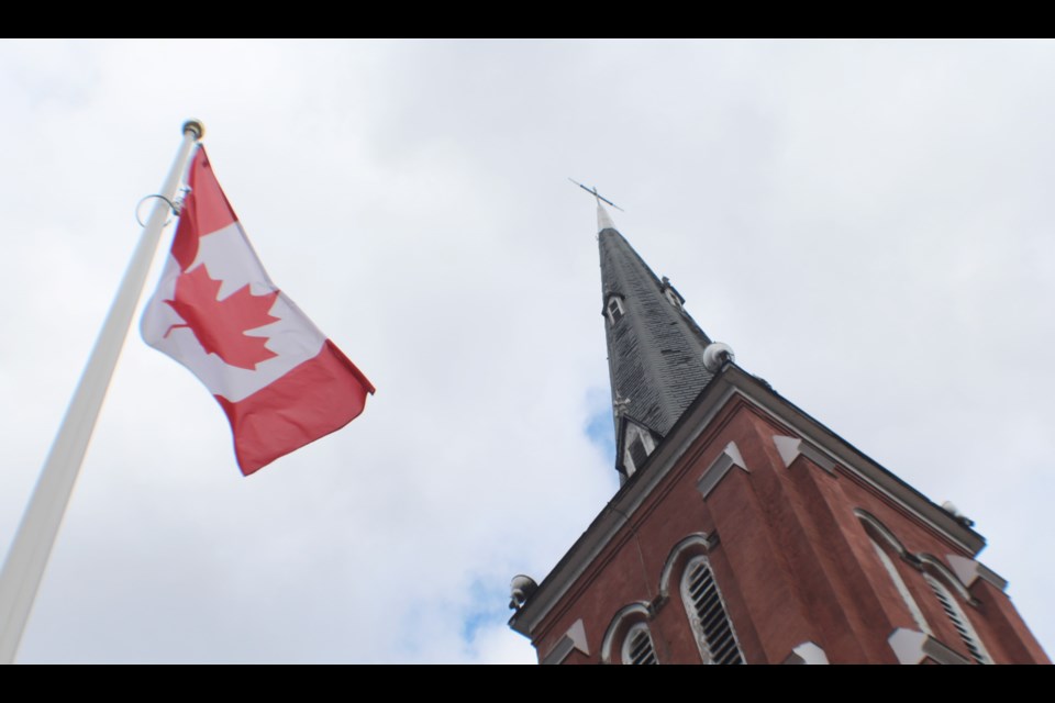 The Canadian flag flies outside Collier Street United Church in downtown Barrie. Collier Street will be one of four Barrie churches taking part in the Bells of Peace on Sunday. Raymond Bowe/BarrieToday