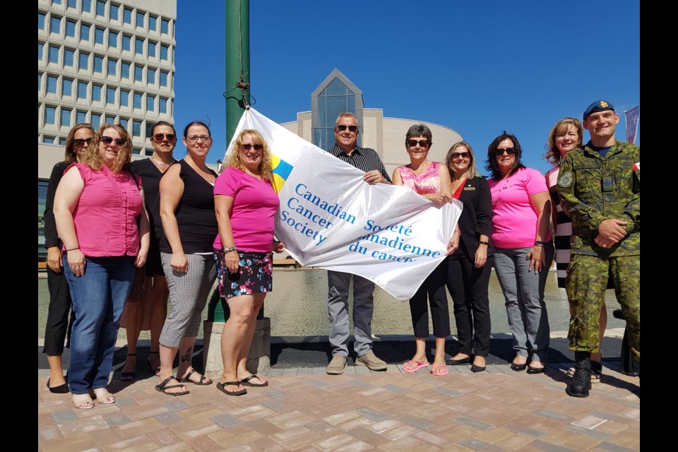 The CIBC Run For The Cure Barrie/Orillia team stands with Coun. Doug Shipley (middle) as the Canadian Cancer Society flag is raised at city hall in Barrie Monday. Shawn Gibson/BarrieToday