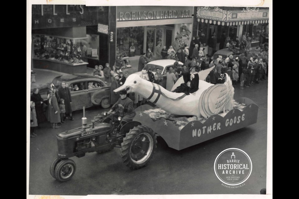 A Mother Goose float passes in front of Robinson Hardware during a 1950s era Santa Claus parade.